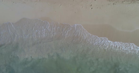 Splash of waves on a beach in the Dominican Republic, with white sand, shot with drone