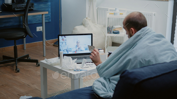 elehealth using laptop. Man holding capsule tablet, asking doctor about prescription medicine and treatment while using online remote conference