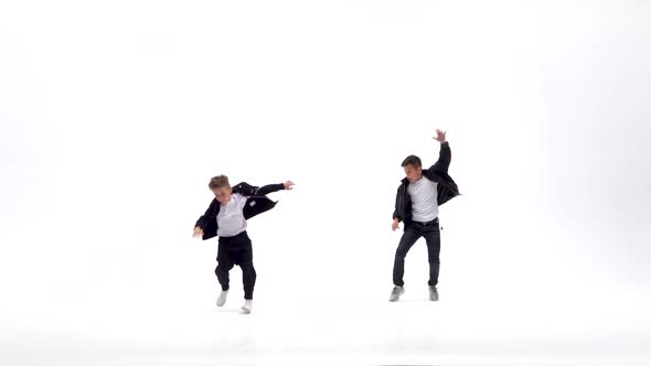 Little Boys Are Dancing a Modern Dance on the White Background in Black Leather Jackets and Jeans