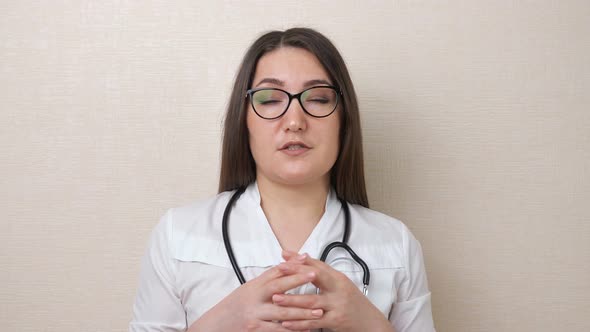 Woman Doctor with Glasses and Stethoscope Talks on Beige