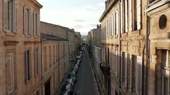 Classic Old Street in Bordeaux, France, Aerial Forward at Sunset with Sunflairs