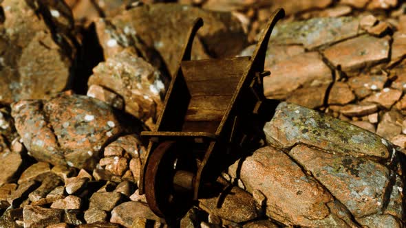 Abandoned Wooden Mine Wheelbarrow on Rocks alt