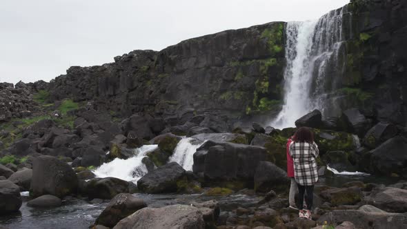 Couple Filming Towards Oxararfoss Waterfall