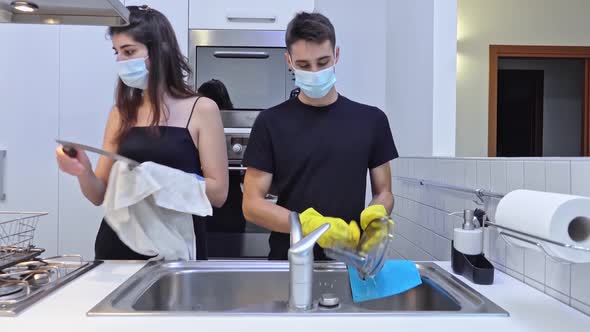 Housekeepers washing the dishes wearing protective mask Home quarantine for coronavirus COVID-19 epi