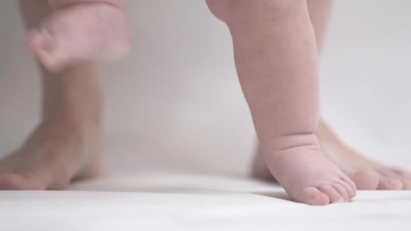 Close-up of a young child's legs learning to walk