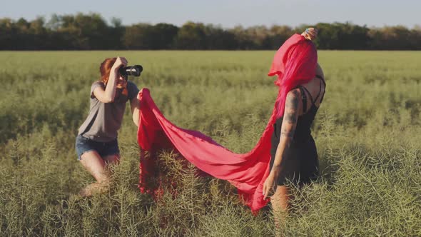 Woman Fashion Photographer Photographing on Camera a Stylish Young Woman Model with Red Hair and