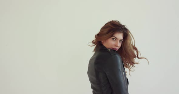 Beautiful Girl Turns to Camera with Waving Hair on Background