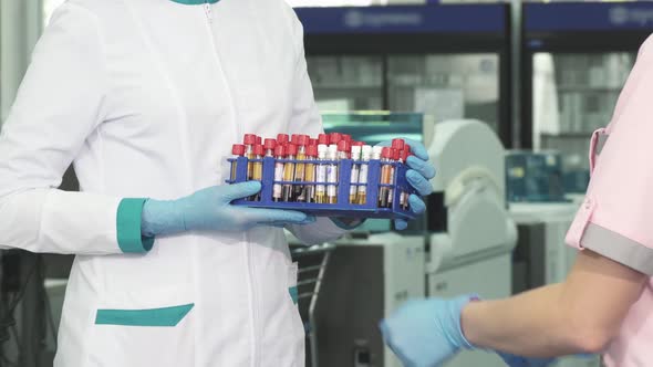 Cropped Shot of a Medical Worker Receiving Blood Test Samples From a Colleague