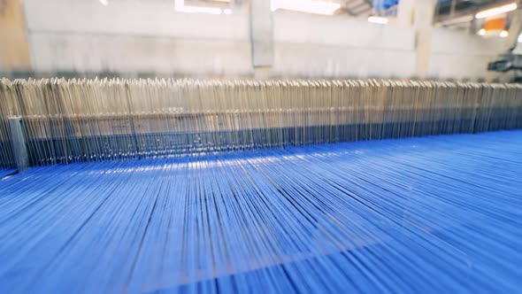 Weaving Machine at Work with Blue Threads Going Through It