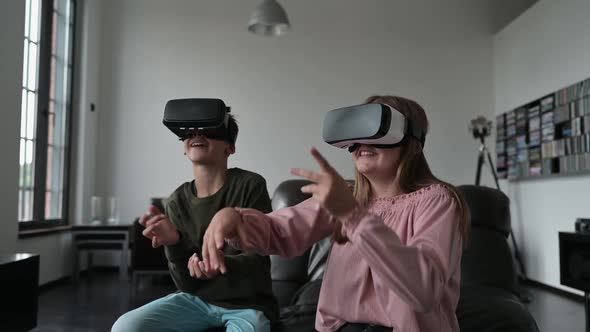 Teenage boy and girl gaming with virtual reality simulators at home
