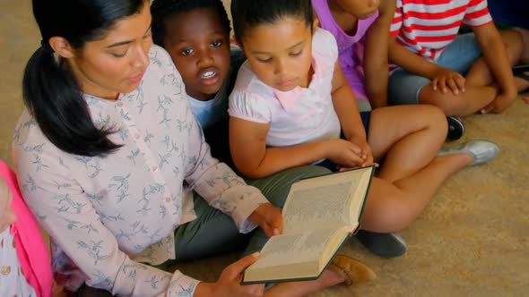 Asian female teacher teaching schoolkids in school library 4k