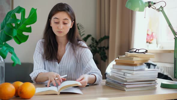 Young Student Preparing for Exams Rewrites a Lecture From a Book Into a Tablet