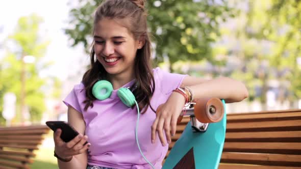 Happy Teenage Girl with Smartphone and Longboard