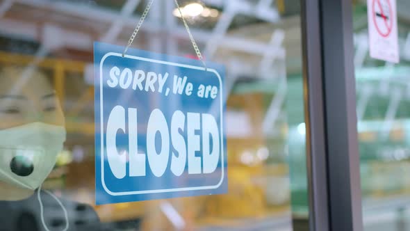 Asian female cafe business owner stressful hand handing shop close again