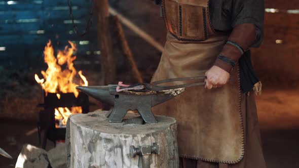 Blacksmith in the Forge Forges a Horseshoe