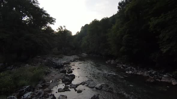 FPV Aerial Shot Dynamic Flying at Natural Landscape River Canyon in the Dense Green Forest and Rapid