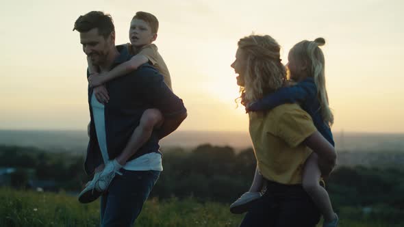 Parents with kids walking at the meadow in summer day. Shot with RED helium camera in 4K.