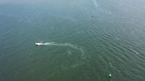 An aerial drone view over Jones Inlet on a sunny day. The camera hovers in place & focuses on a smal