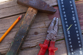 On wooden floor are old construction tools, hammer, pencil, ruler and pliers with red handles. - PhotoDune Item for Sale