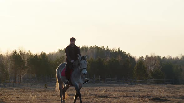A Man Rides a Gray Horse at Dawn