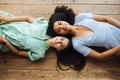 Two young women lie head to head on the floor - PhotoDune Item for Sale