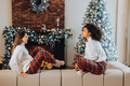 Two female student friends sitting on the couch at home - PhotoDune Item for Sale
