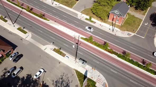 Drone flying over traffic on a beautiful city street.