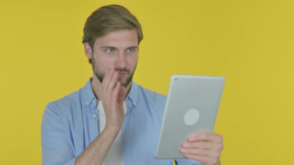 Video Call on Tablet By Young Man on Yellow Background