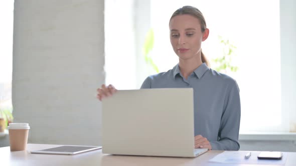 Woman Leaving Office After Closing Laptop