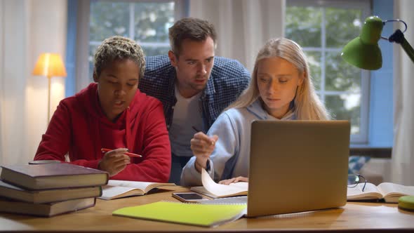 Diverse Friends Studying Together in University Common Room Preparing for Exams