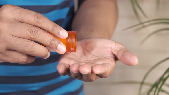 Man's Hand with Medicine Spilled Out of the Pill Container