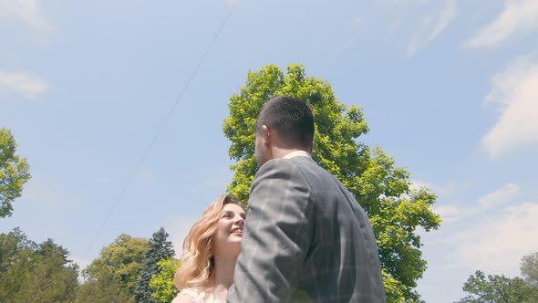 Young Wedding Couple in Love Newlyweds Walking in a Fabulous Sunny Park on a Background of Green