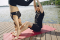 Man and woman doing yoga exercises by the water - PhotoDune Item for Sale