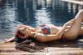 Portrait of a young girl in a swimwear lying near pool - PhotoDune Item for Sale