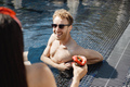 Caucasian man standing in a swimming pool and talking with a girl - PhotoDune Item for Sale