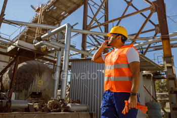 afety glasses talking on cellphone while walking at manufacturing facility of plant