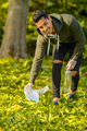 Close-up of dedicated volunteer cleaning garbage on grass in nature - PhotoDune Item for Sale