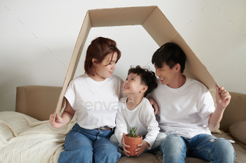 ent when they are sitting under cardboard roof symbolyzing house
