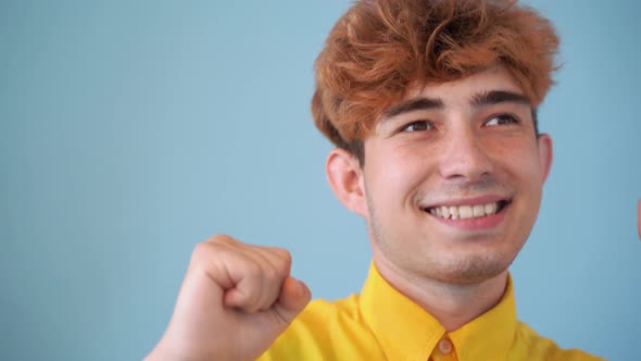 Close Up Boy Dancing Wearing Yellow Shirt on Blue Background