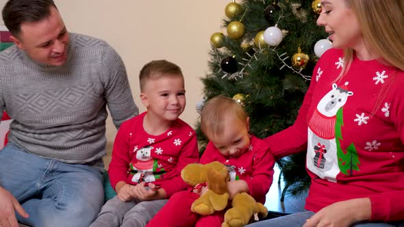 Happy Family Having Fun and Playing Together Near Christmas Tree Children Kiss