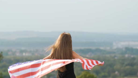 Young Happy Woman with Long Hair Holding Waving on Wind American National Flag on Her Sholders