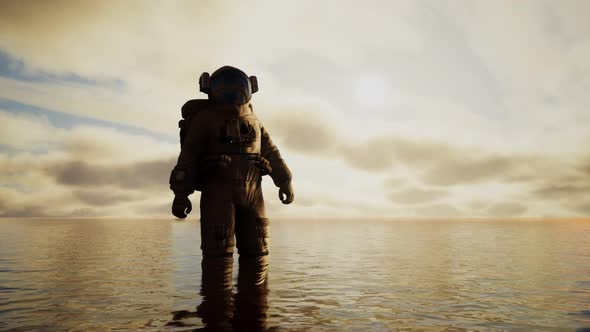 Spaceman in the Sea Under Clouds at Sunset