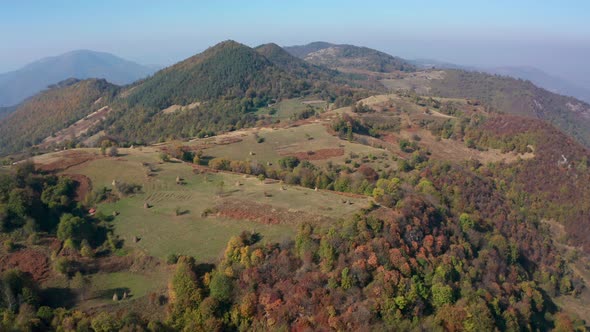 Autumn mountain with peaks, meadows and colorful forests