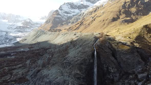 very special beautiful waterfall in a barren valley in the swiss mountains (Zmuttbach)
