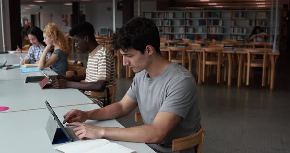 Group of young students learing together inside school library