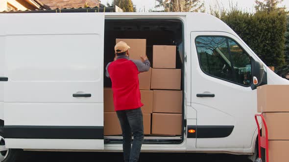 Young Delivery Man Putting Parcel Into the Van