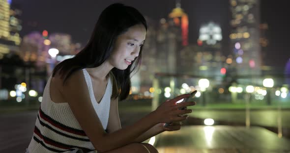 Woman using smart phone at night 