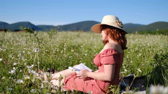 Beautiful Young Woman in Chamomile Field