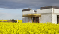 Rural house under construction in rapeseed field. - PhotoDune Item for Sale