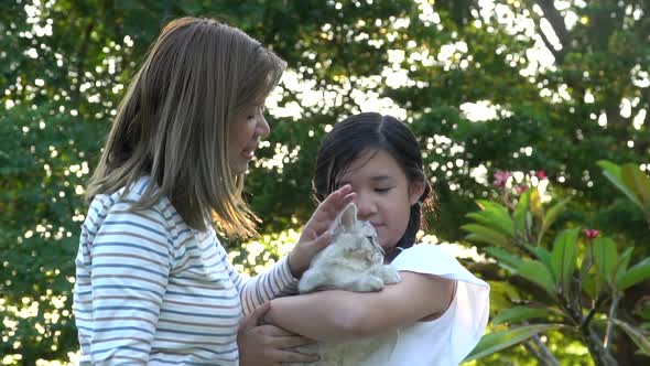 Asian Mother Playing A Kitten To Her Daughter 